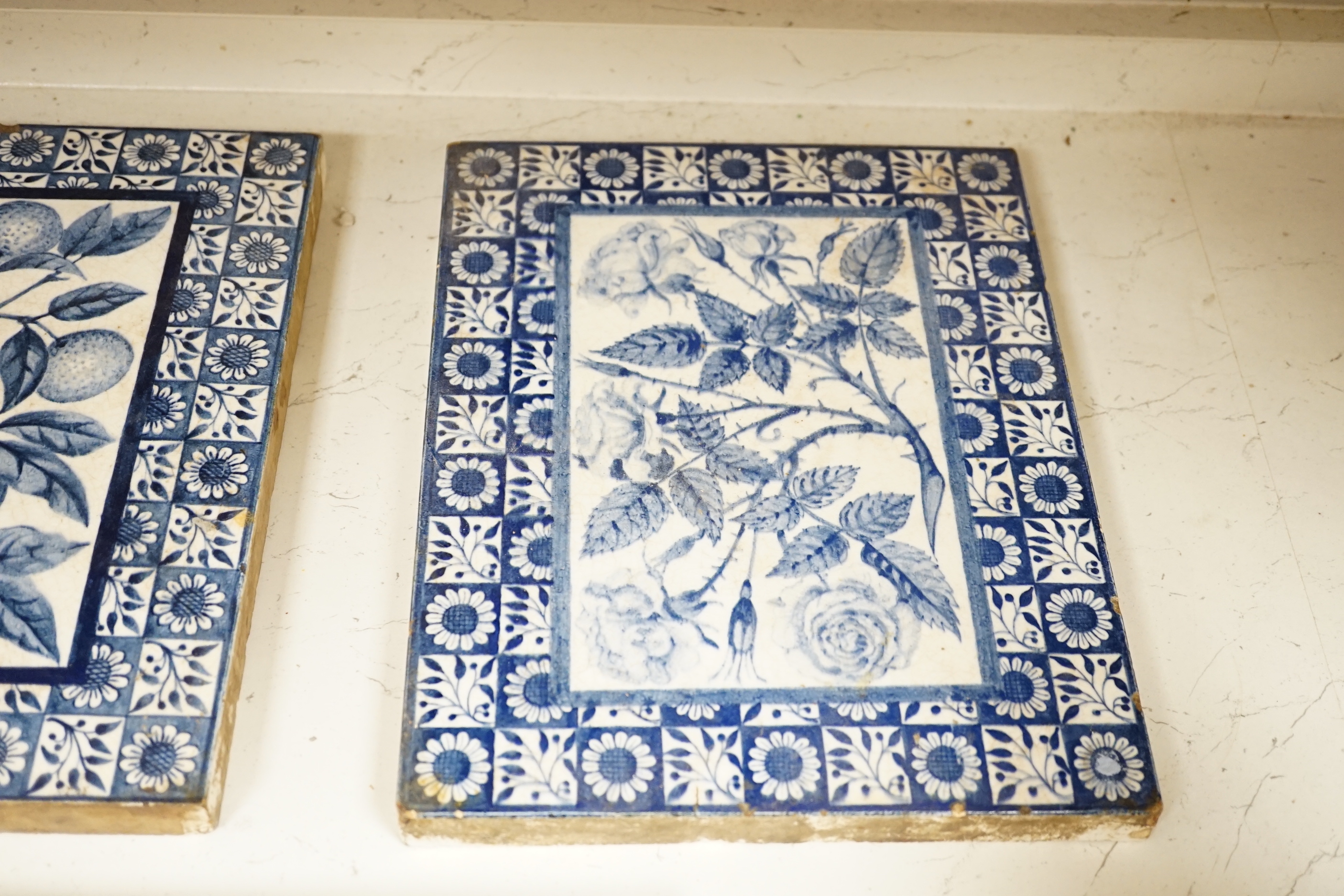 Three Victorian blue and white Mintons tiles decorated with flowers and fruit, each stamped to the base, each 29cm x 22cm